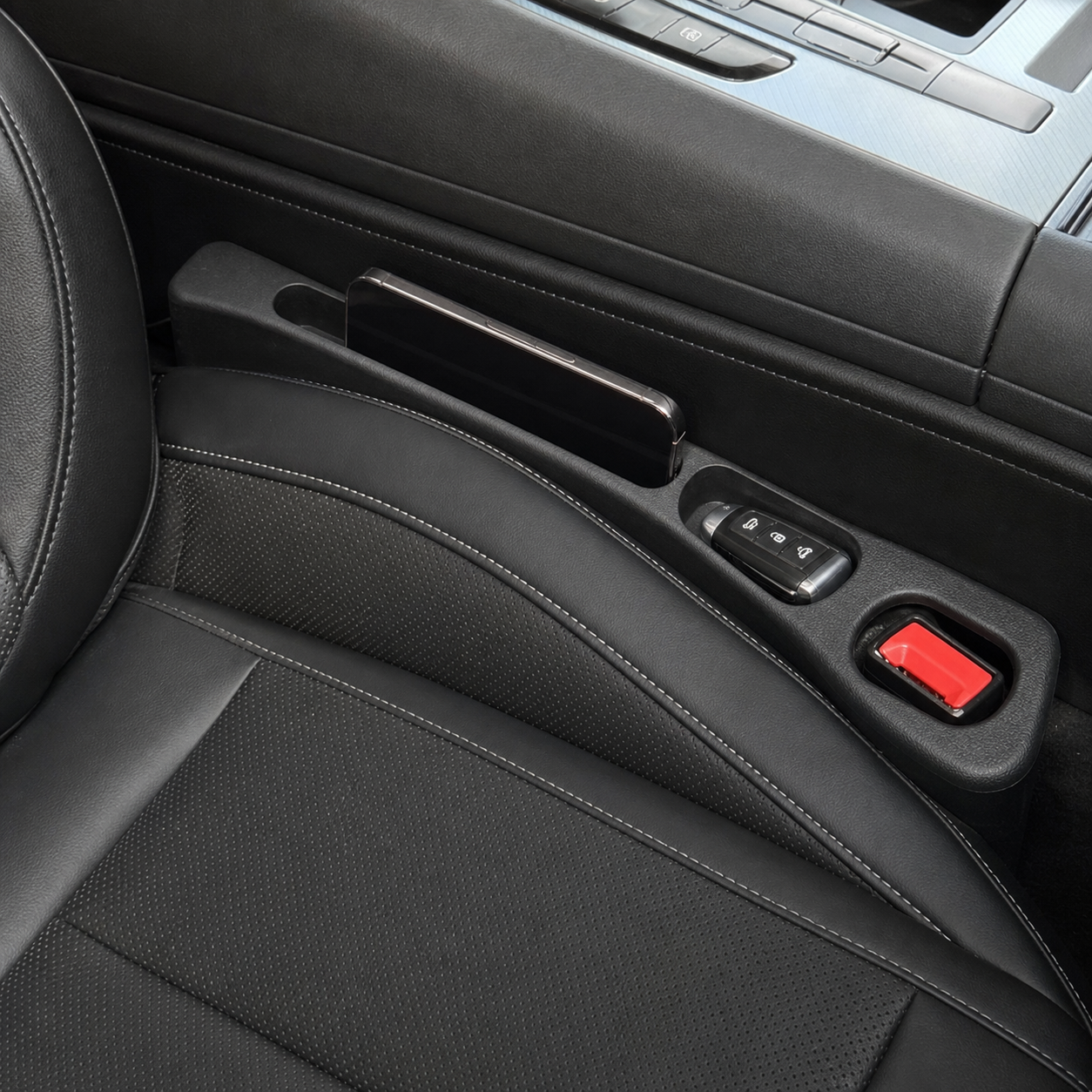 Seat Seal installed beside a black leather car seat holding a phone and key